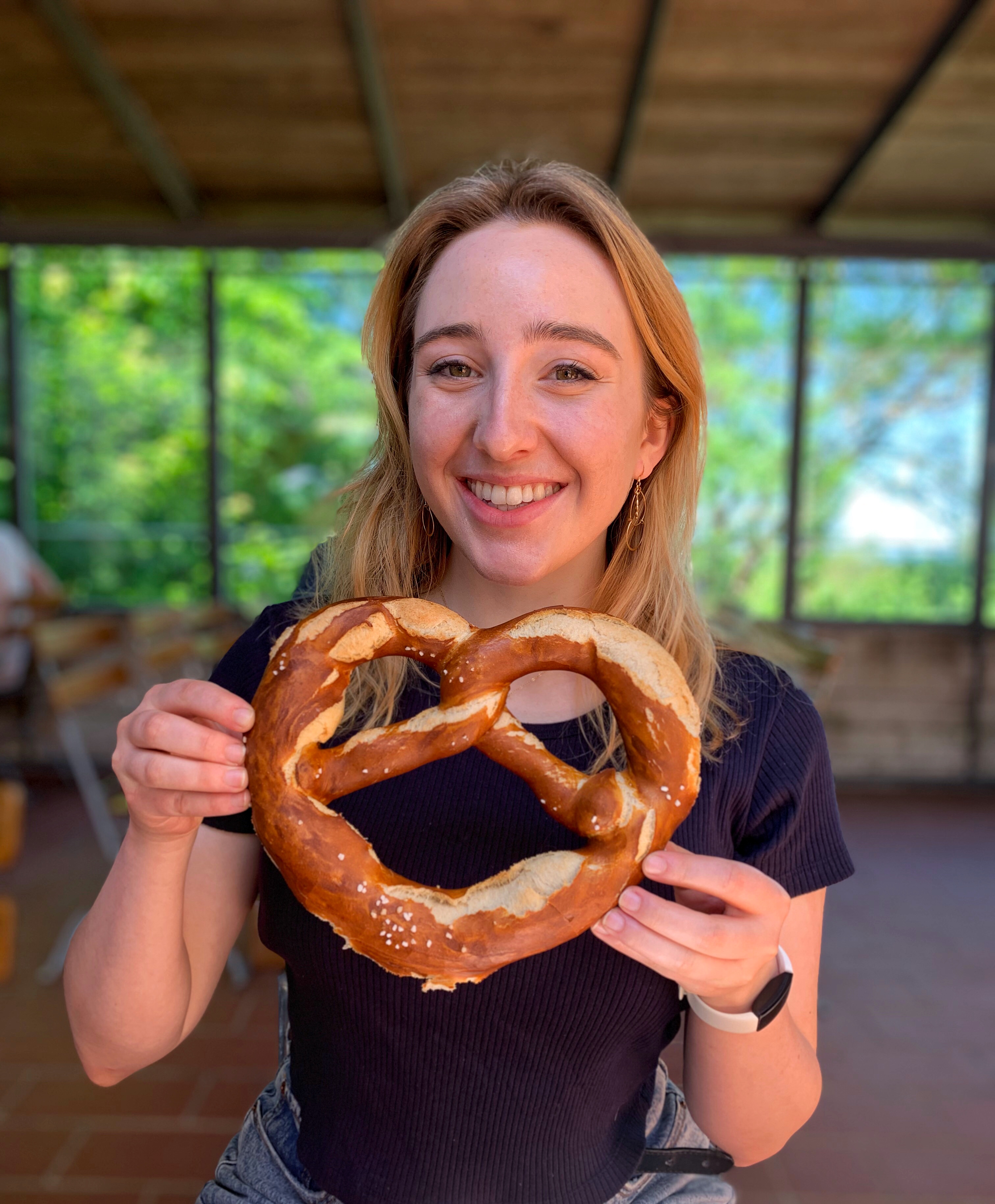 German student holds large pretzel