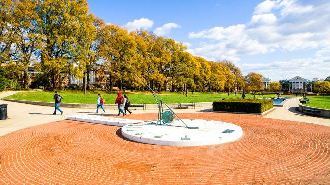 A photo of the sundial on McKeldin Mall and students passing by